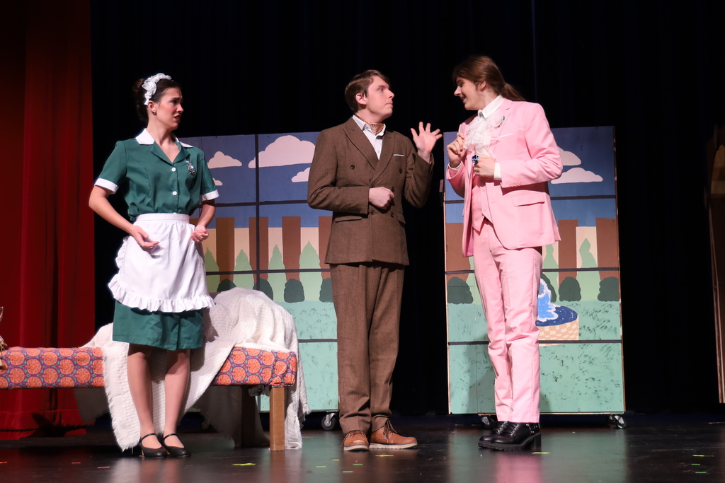 A maid and an angry man talking to another character in pink suit 