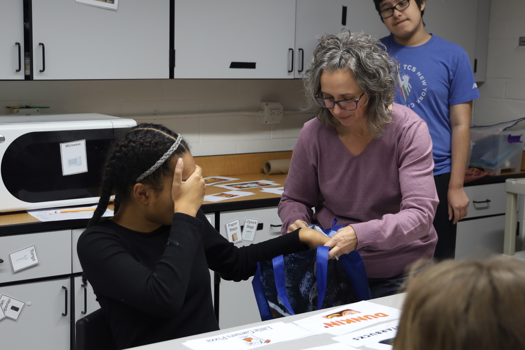 Student with eyes closed, teacher holding bag