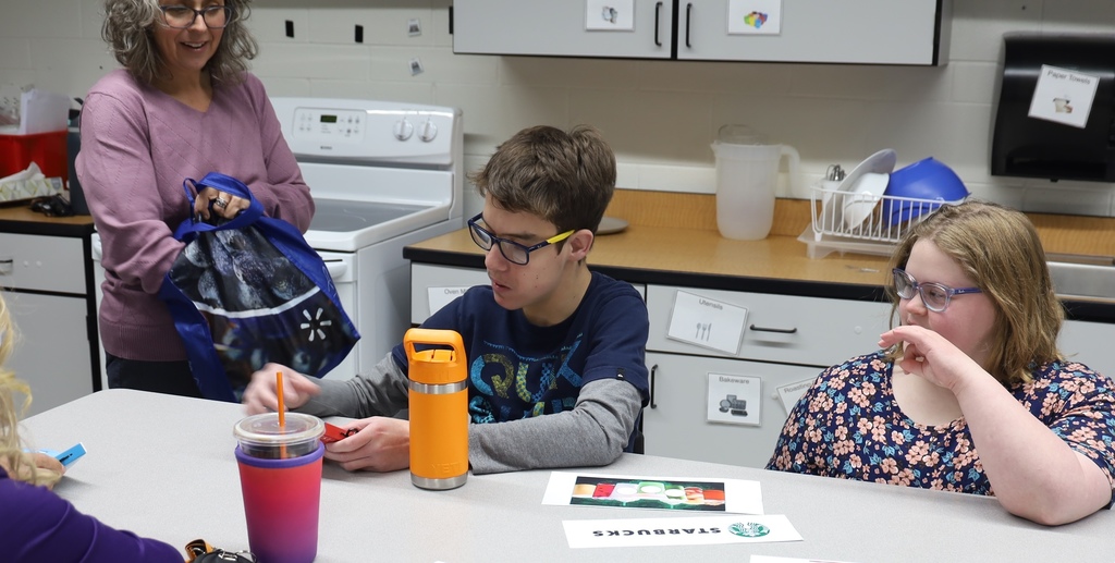 Student holding something teacher holding bag