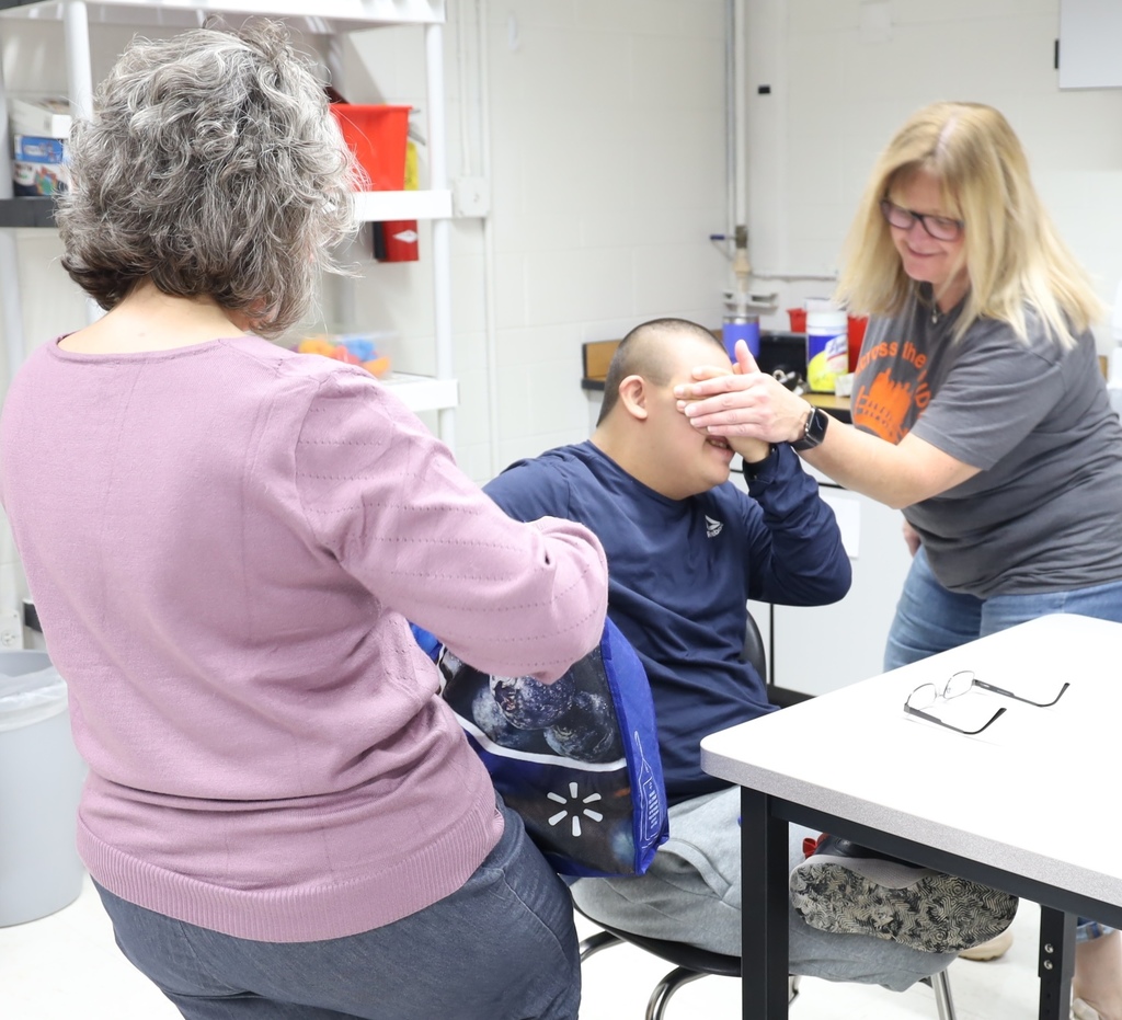 Student with eyes closed, teacher holding bag