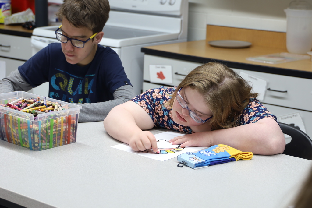 Student coloring with socks next to them