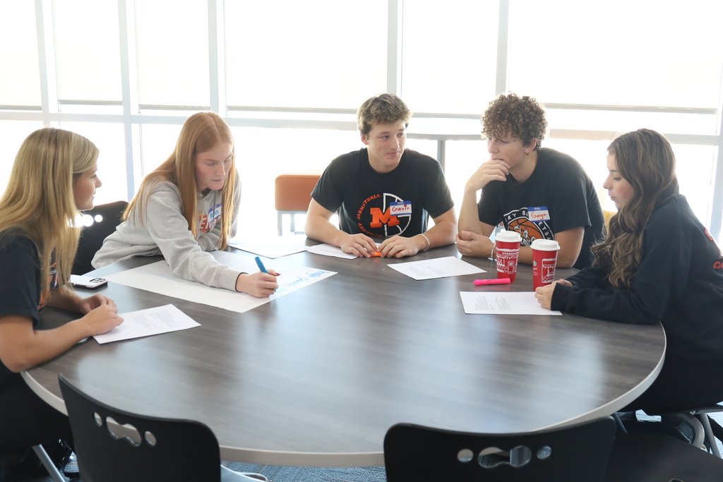 Students working on writing things down at a table