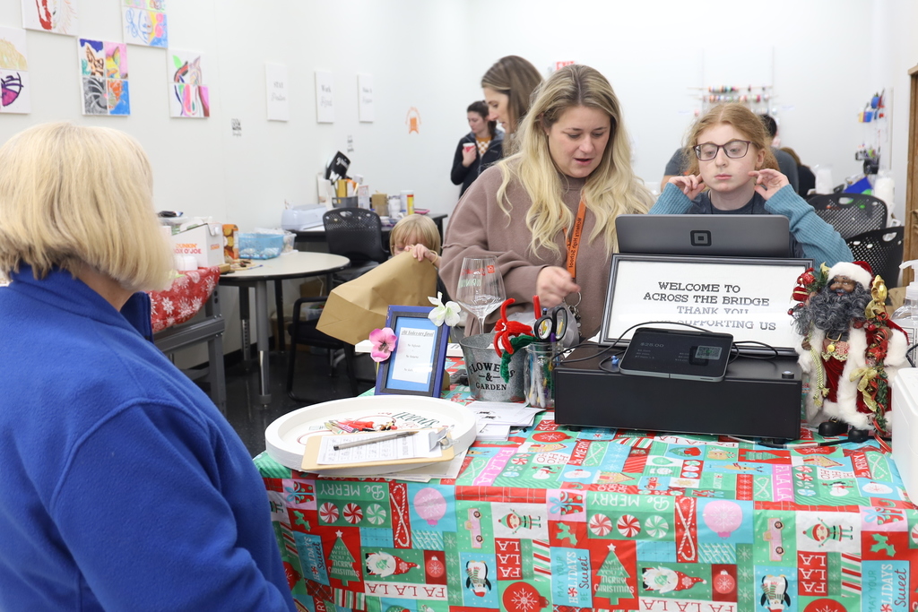 Someone checking out at the Bridges store with people helping at the register