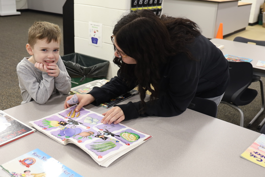 Preschooler with high schooler reading a book
