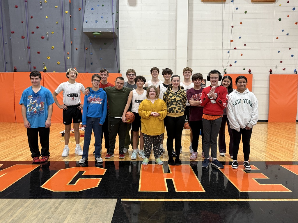 Group of students posing together on the basketball gym floor 