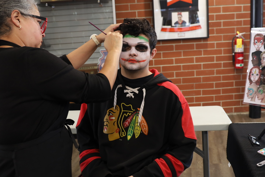 Student getting a Joker makeup on his face 