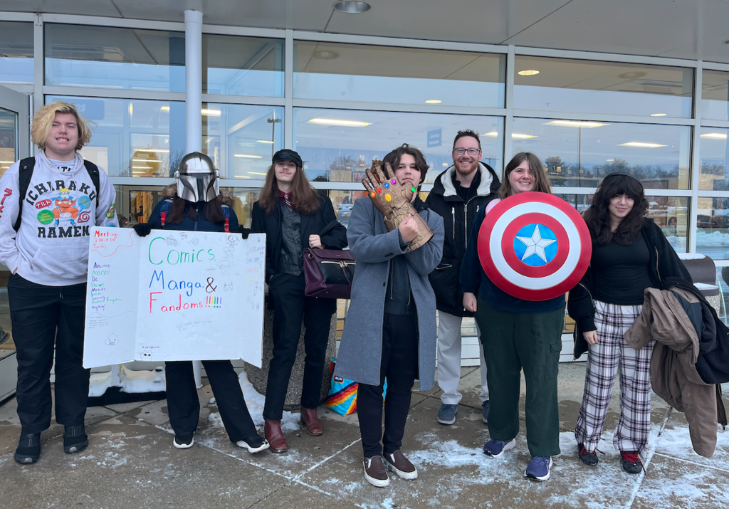 Group of students and advisor with a comics manga and fandoms poster, Thanos hand, Captain America shield and Mandolorian helmet