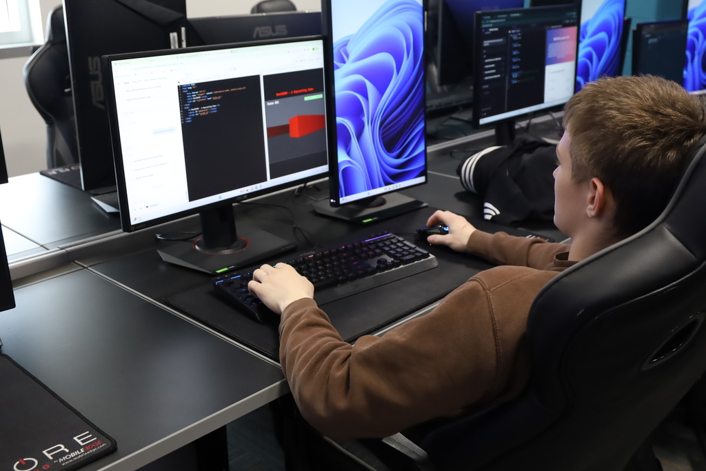 A student coding and playing a game on the computer 