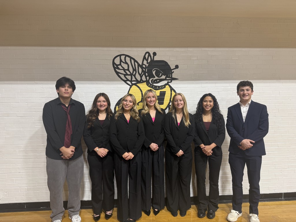 Group of students standing in front of a wall