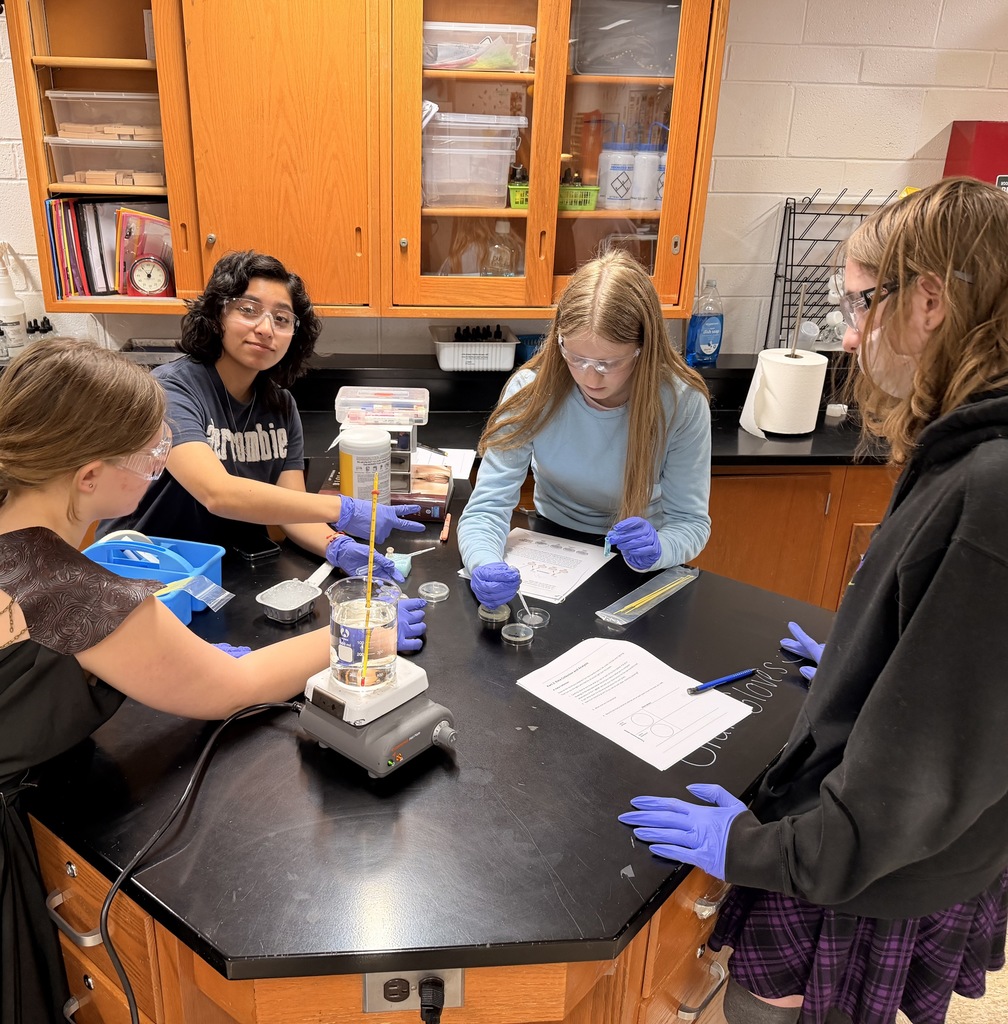 Students working on the science lab. One putting a sample into the dish