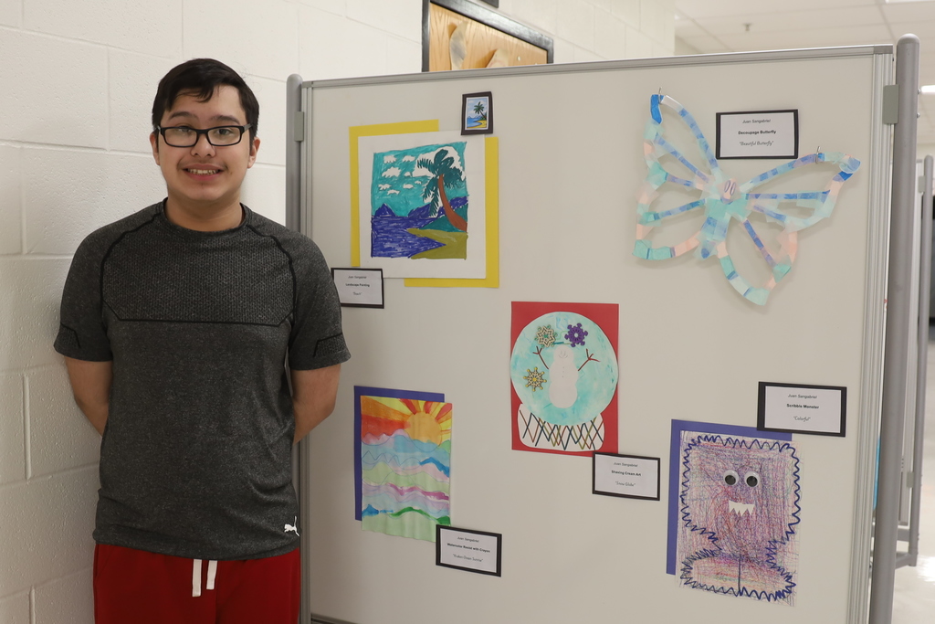 Student standing with artwork