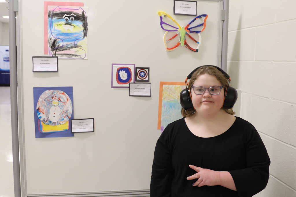 Student with their artwork Artwork: butterfly snow globe, sunset monster