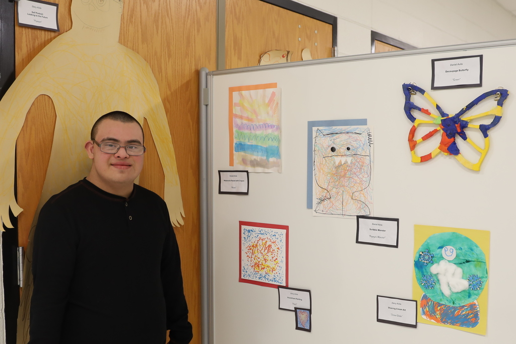 Student with their artwork Artwork: butterfly snow globe, sunset monster