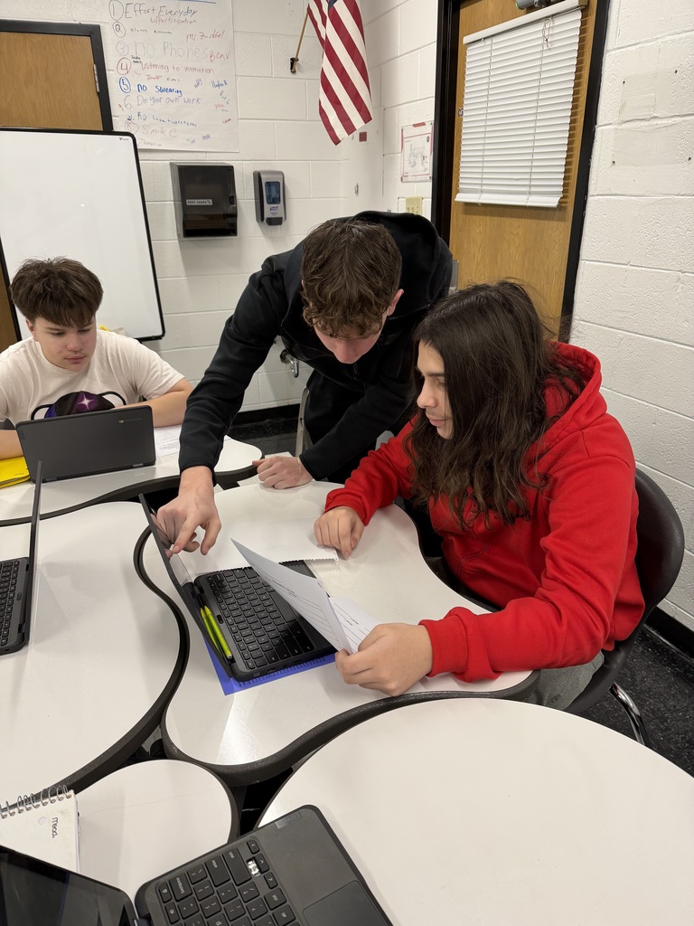 Student helping student on the computer