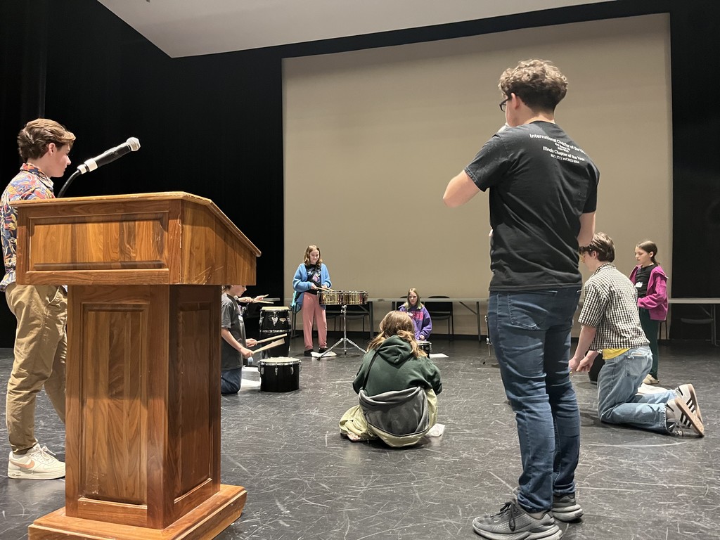 Students sitting in a circle with drusm