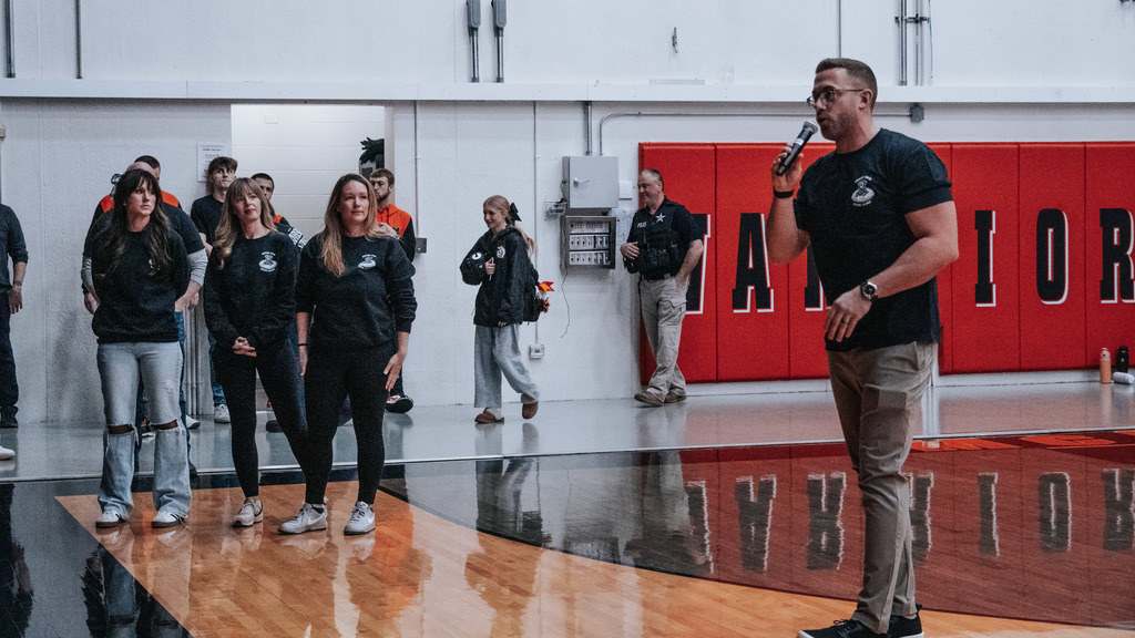 Coach Madson speaking next to Riverside people 