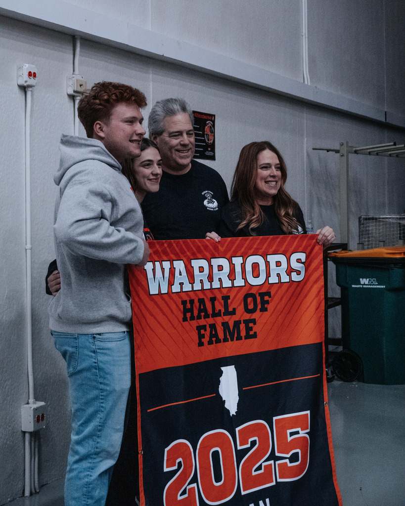 Coach Rockweiler with his family holding Hall of Fame banner 