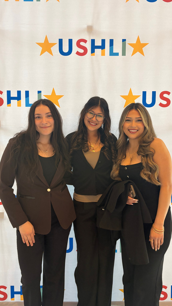 Students standing in front of USHLI poster
