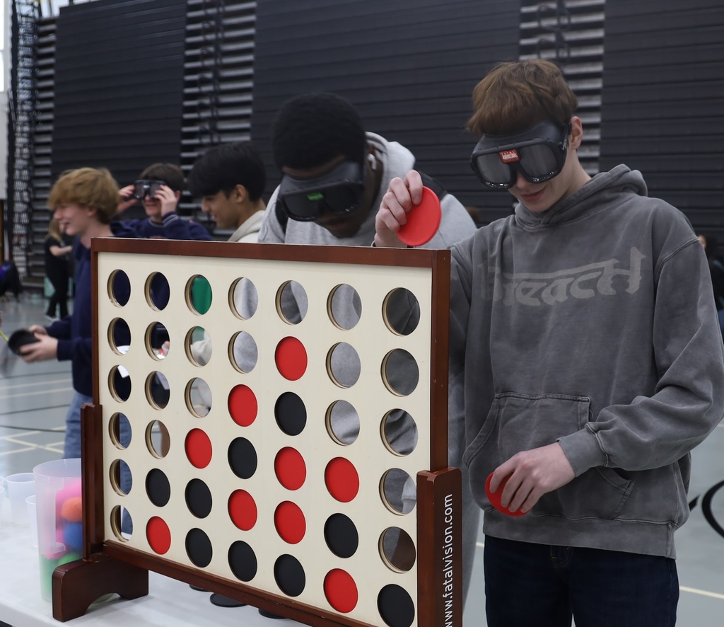 Students playing connect four with impairment goggles on