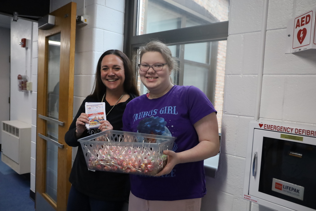 Staff member and student holding goodies basket