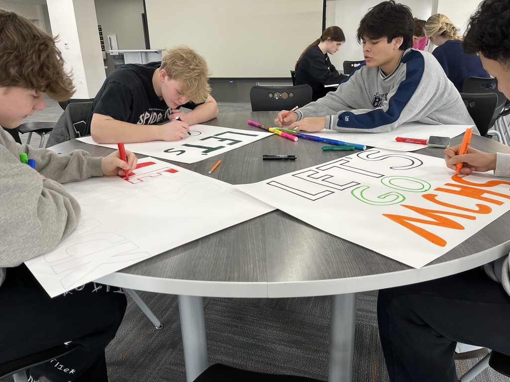 Students making posters, one says, Let's Go MCHS