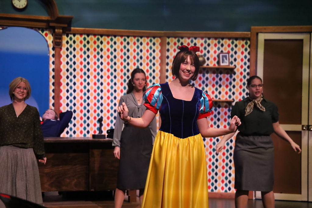 Student singing and smiling in Snow White dress 