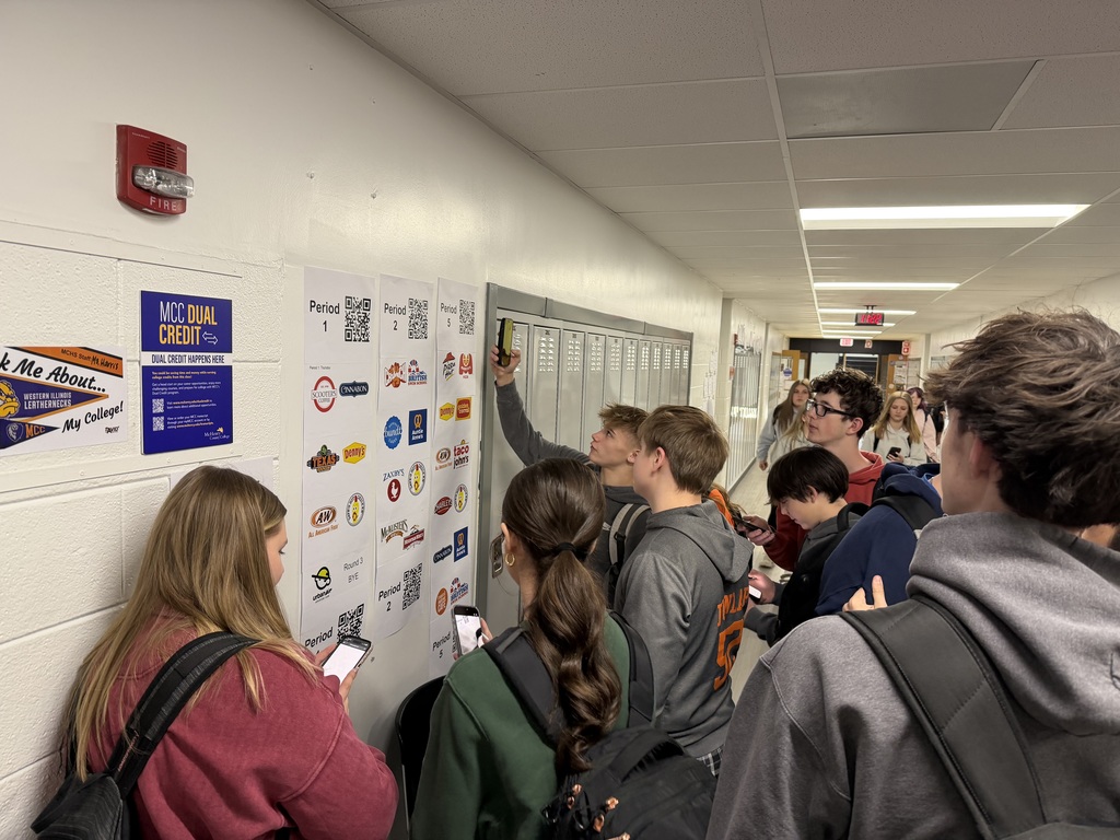 Students looking at the wall of franchises and voting on their phones