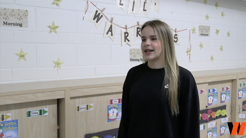 Student talking in front of preschool wall