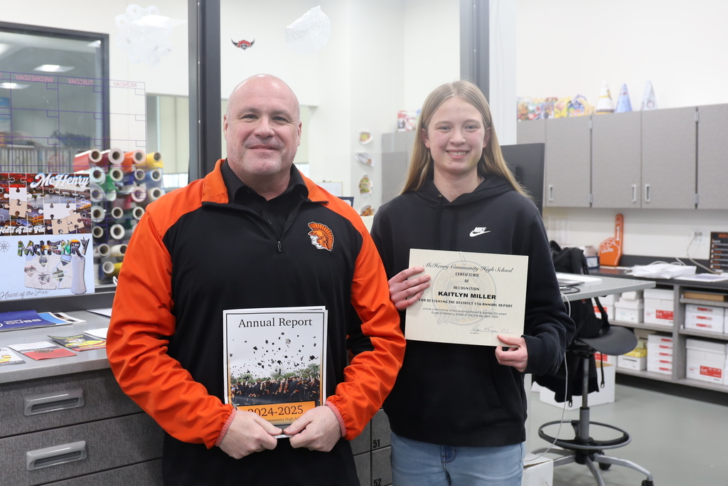 Kaitlin holding certificate with Dr. McTague holding annual report 