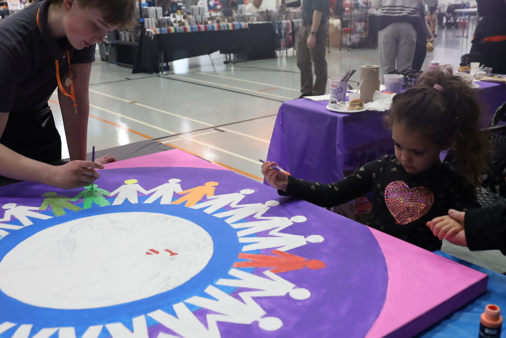 Student and child painting colorful people around the world