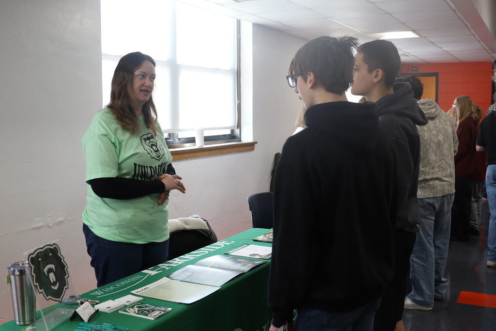 Two students talking to a college representative