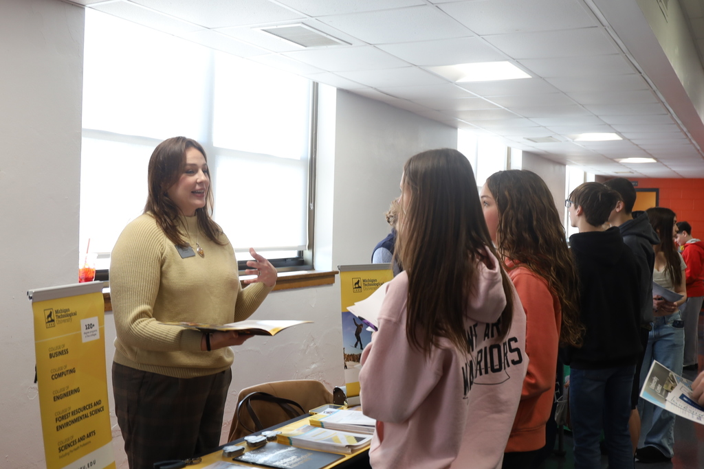 Two students talking to a college representative