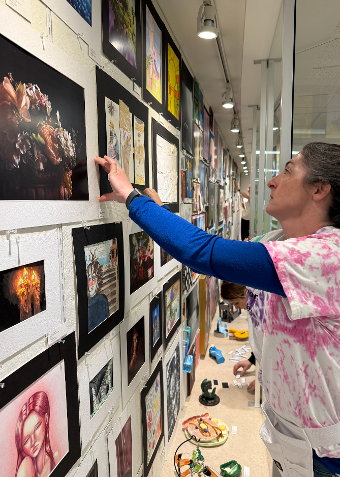 Teacher hanging up art