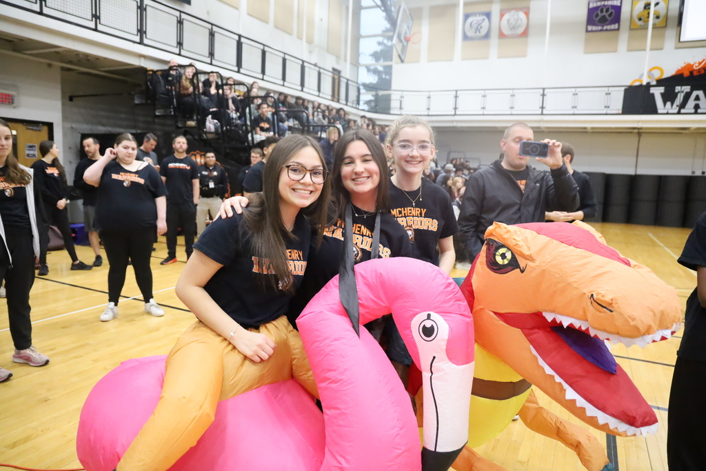 Students wearing inflatable flamingo and dinosaur costumes.