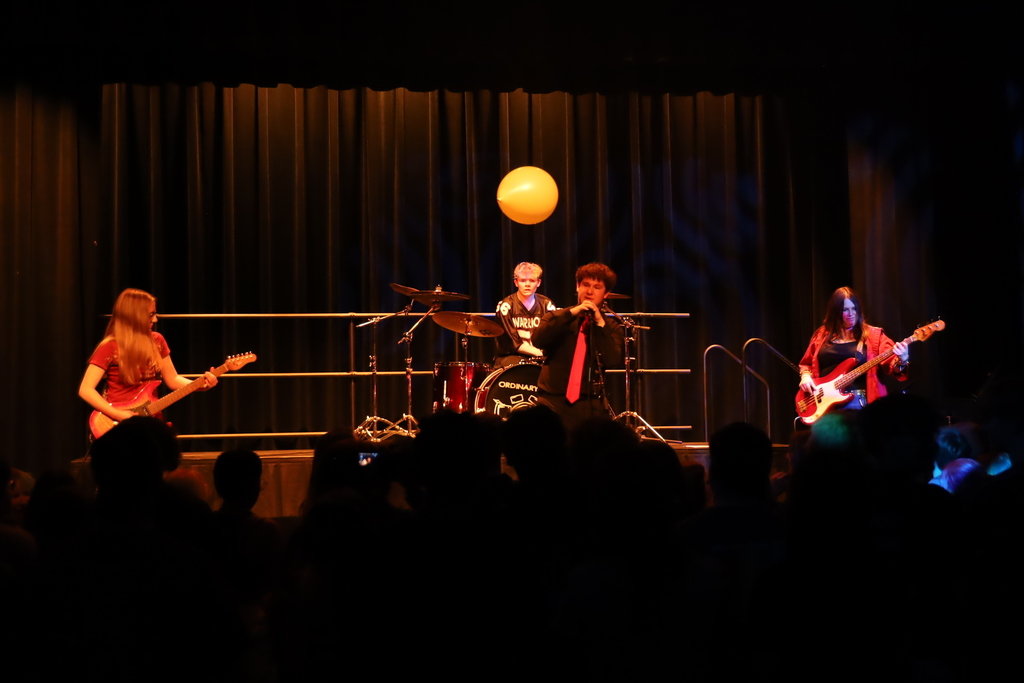 A full band on stage with balloon in the air