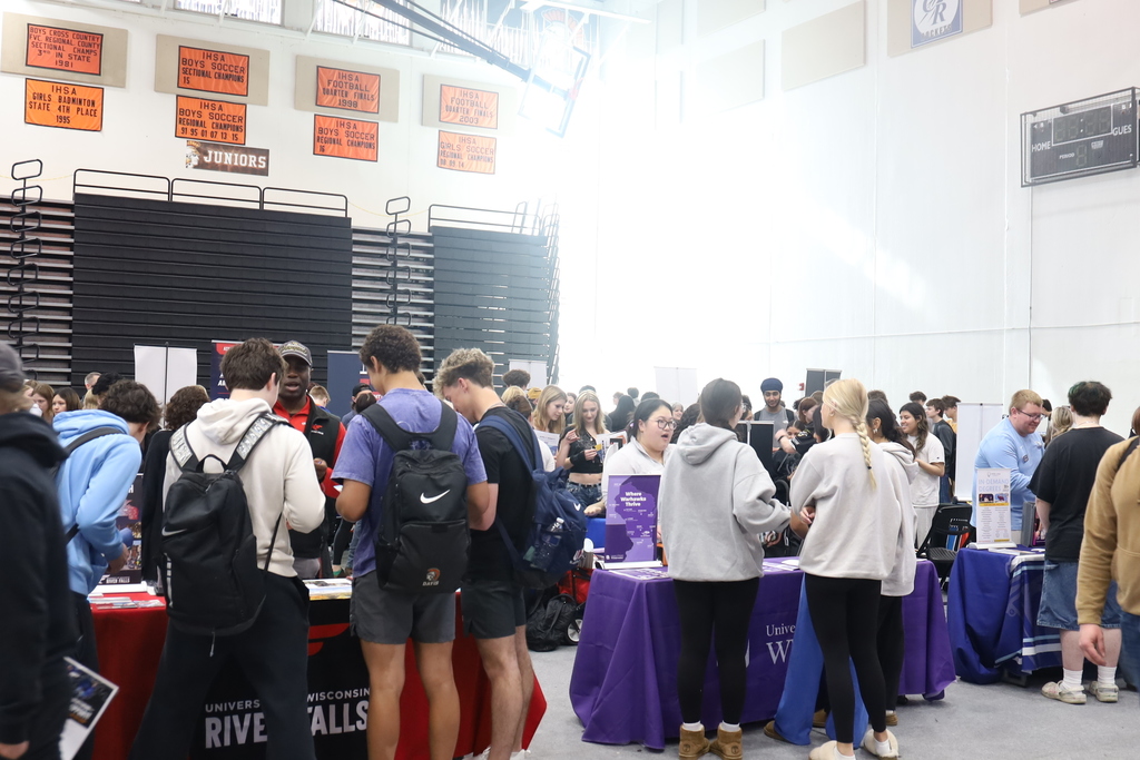 Wide shot of students talking to representatives at multiple tables