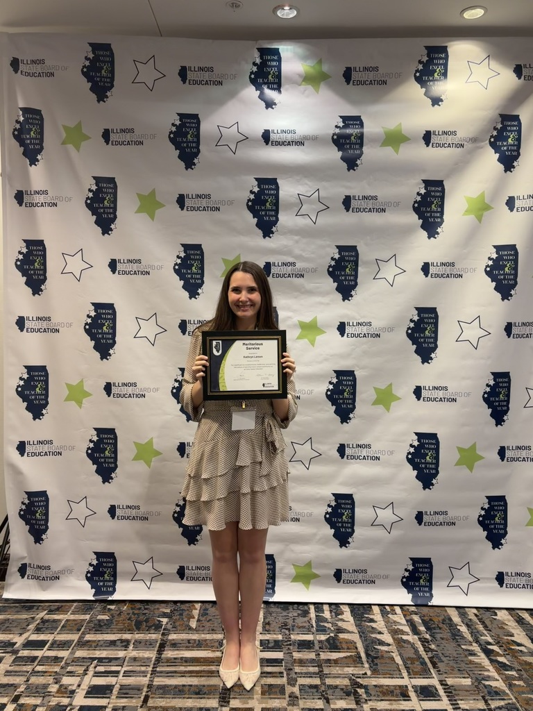 Kathryn Larson holding award in front of ISBE background
