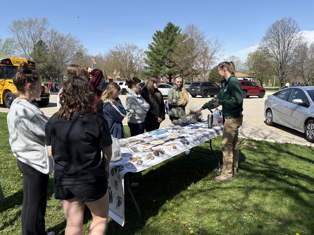 Students outside around a table with instructor 