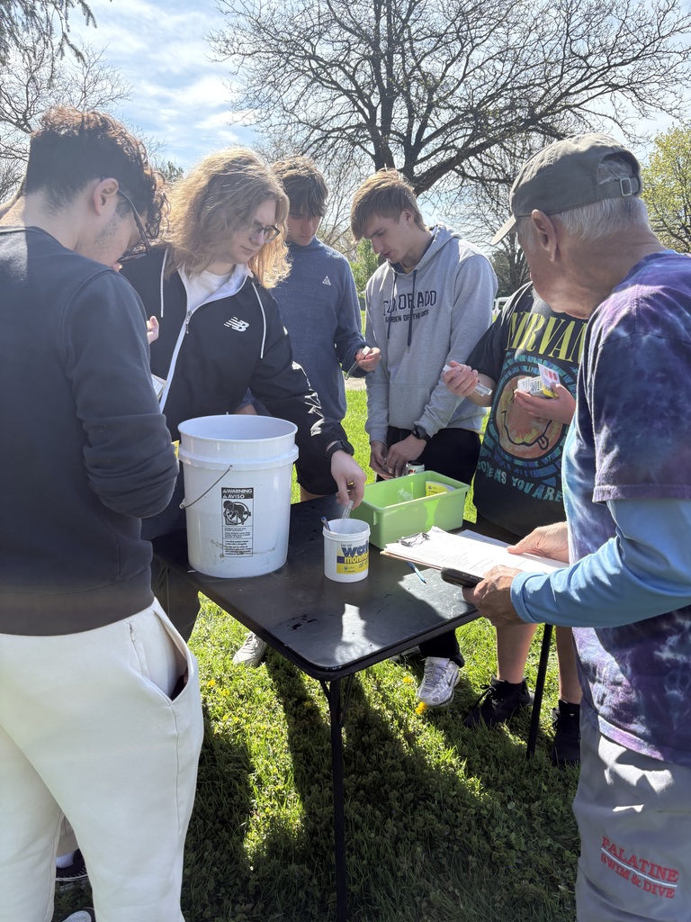 Students around a table testing water