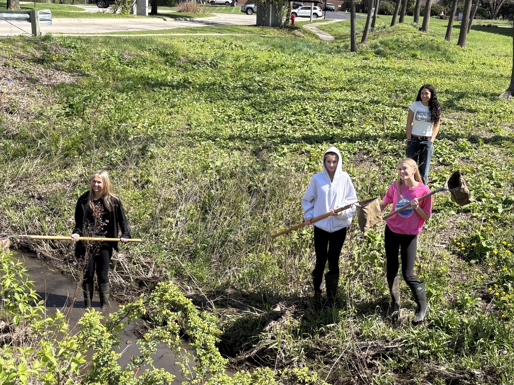 Students with yard tools in field