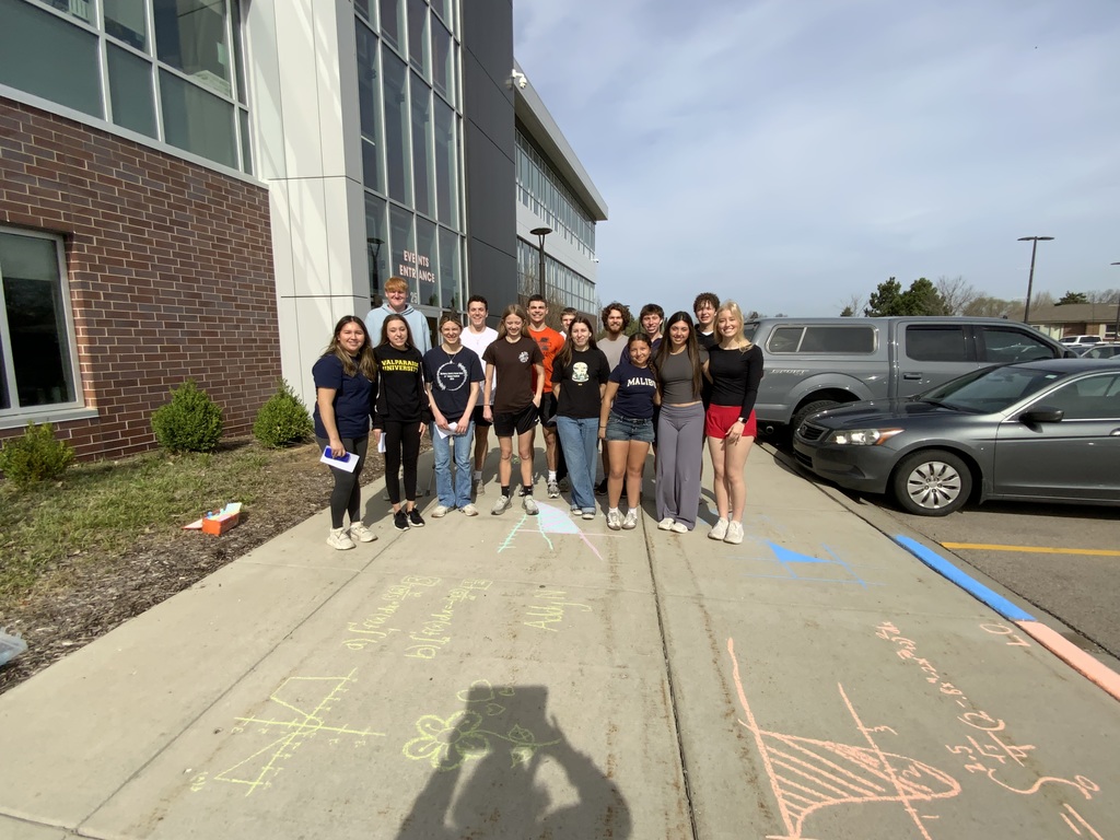 Students in front of sidewalk chalk with mathematical equations