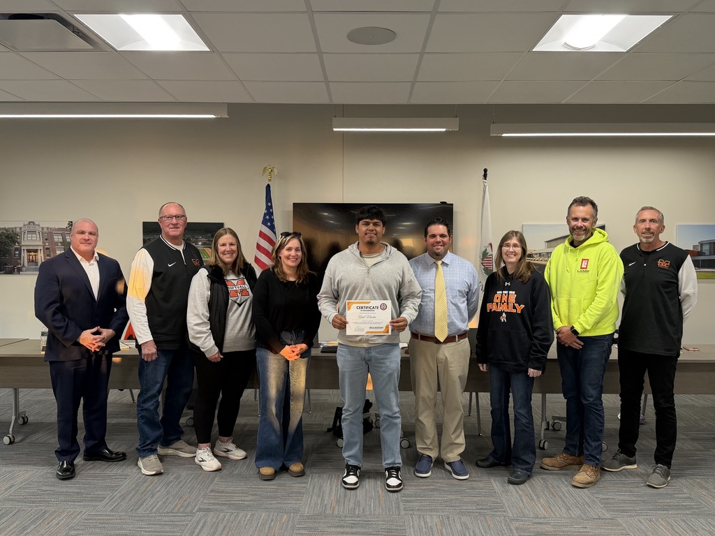 Ariel holding his certificate next to board members, Nick Valenziano and superintendent