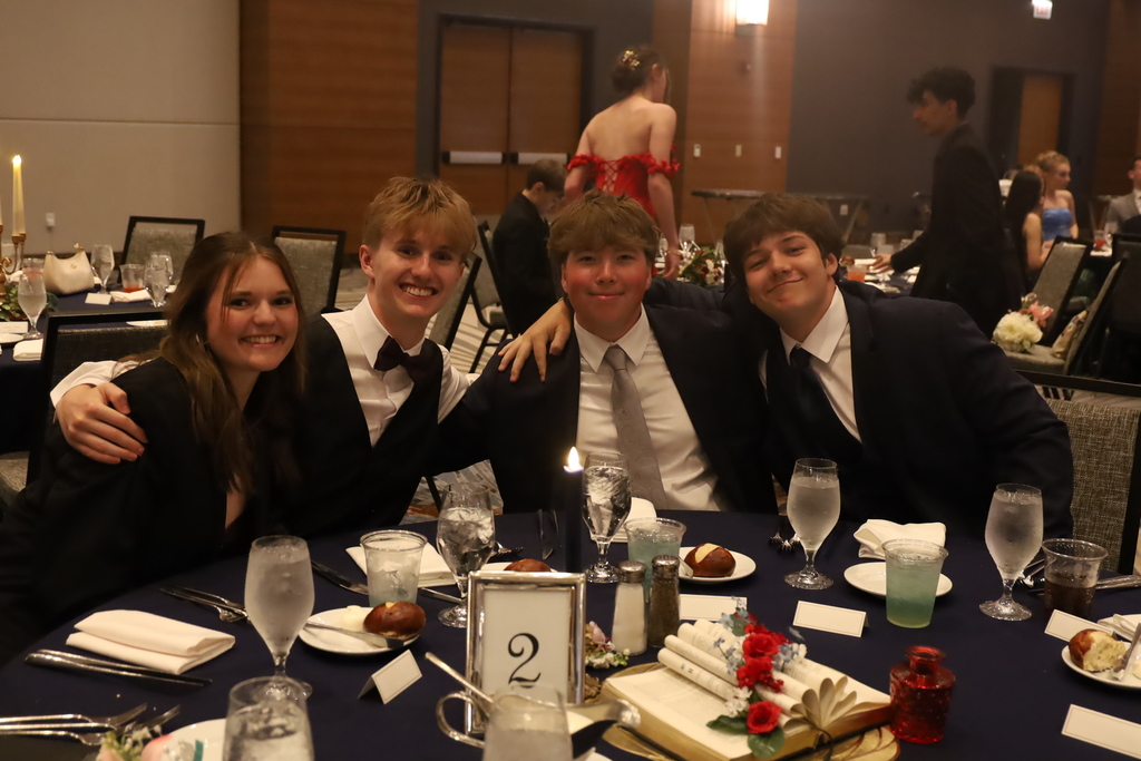 Four students posing at table 