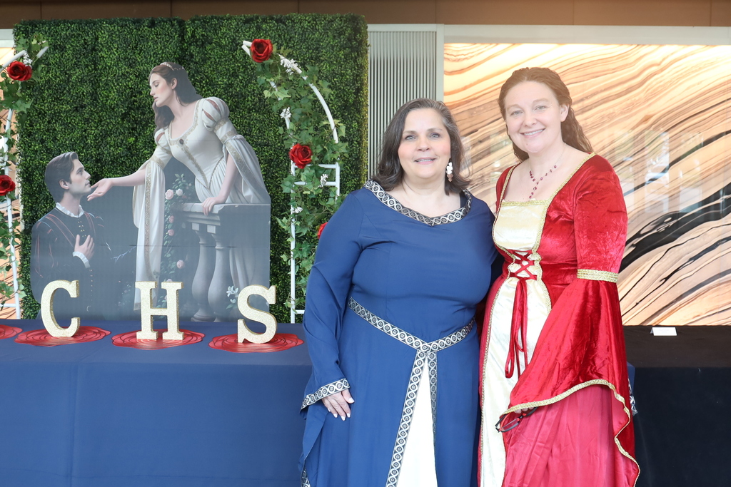 Teachers Gina Adams and Megan Steck posing by Romeo and Juliet decor