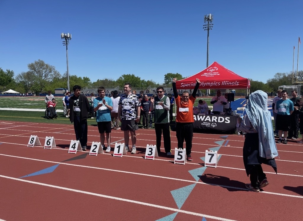 Students standing on track one throwing hands up
