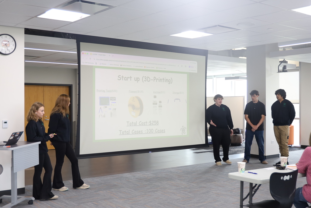 Five students presenting in front of a Start Up (3D printing) slide