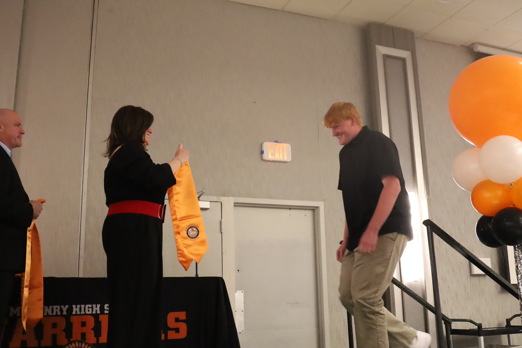 Student walking up stage to get stole