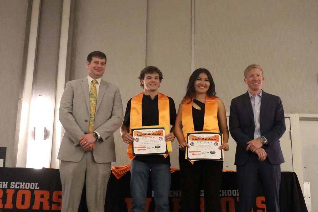 Two men with two students holding awards