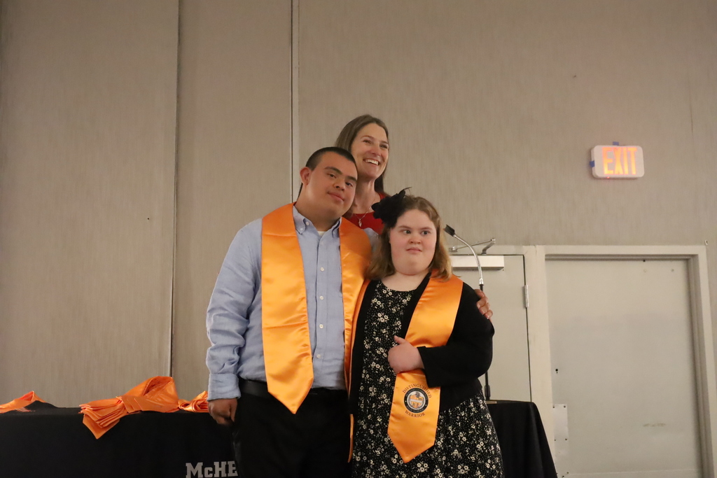 Two students with stoles and an administrator