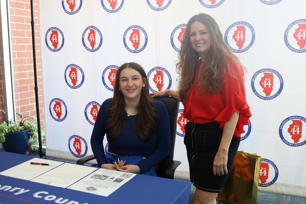 Kaitlyn and Regional Superintendent with Regional Office of Education McHenry, IL logo backdrop